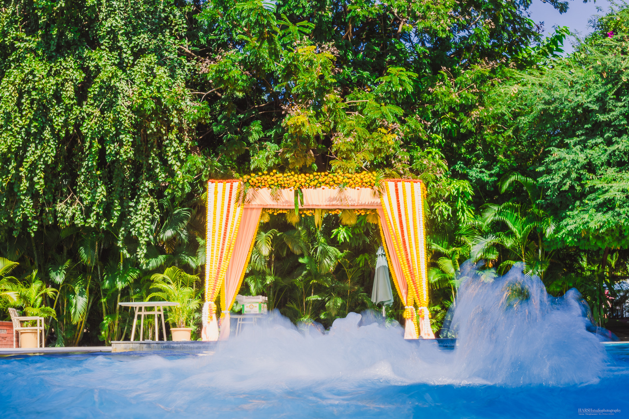Poolside mandap with floral drapes in the party garden at Unwind Resort